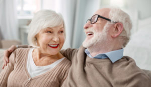 A senior woman and man sitting on a couch. The man has his arm resting on the woman's shoulder as they laugh together. Independent Living Olympus Residential Living provides residents the opportunity to downsize and live comfortably in a space that allows more time to do the things they enjoy. With a variety of locations and floorplans, there is a place for everyone at Olympus.